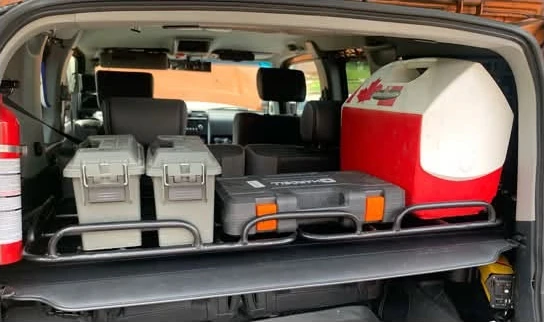 Toolboxes and containers on Sam’s cargo shelf with the cargo cover beneath
